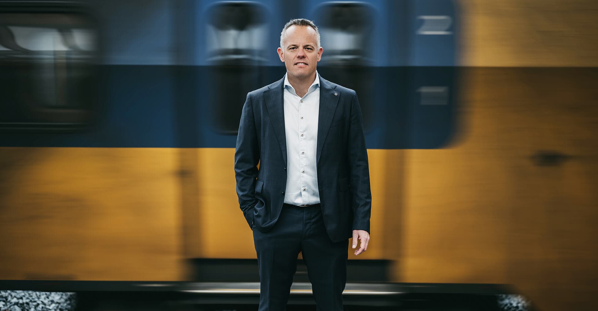 Portret van Nico Hanhart op een treinperron